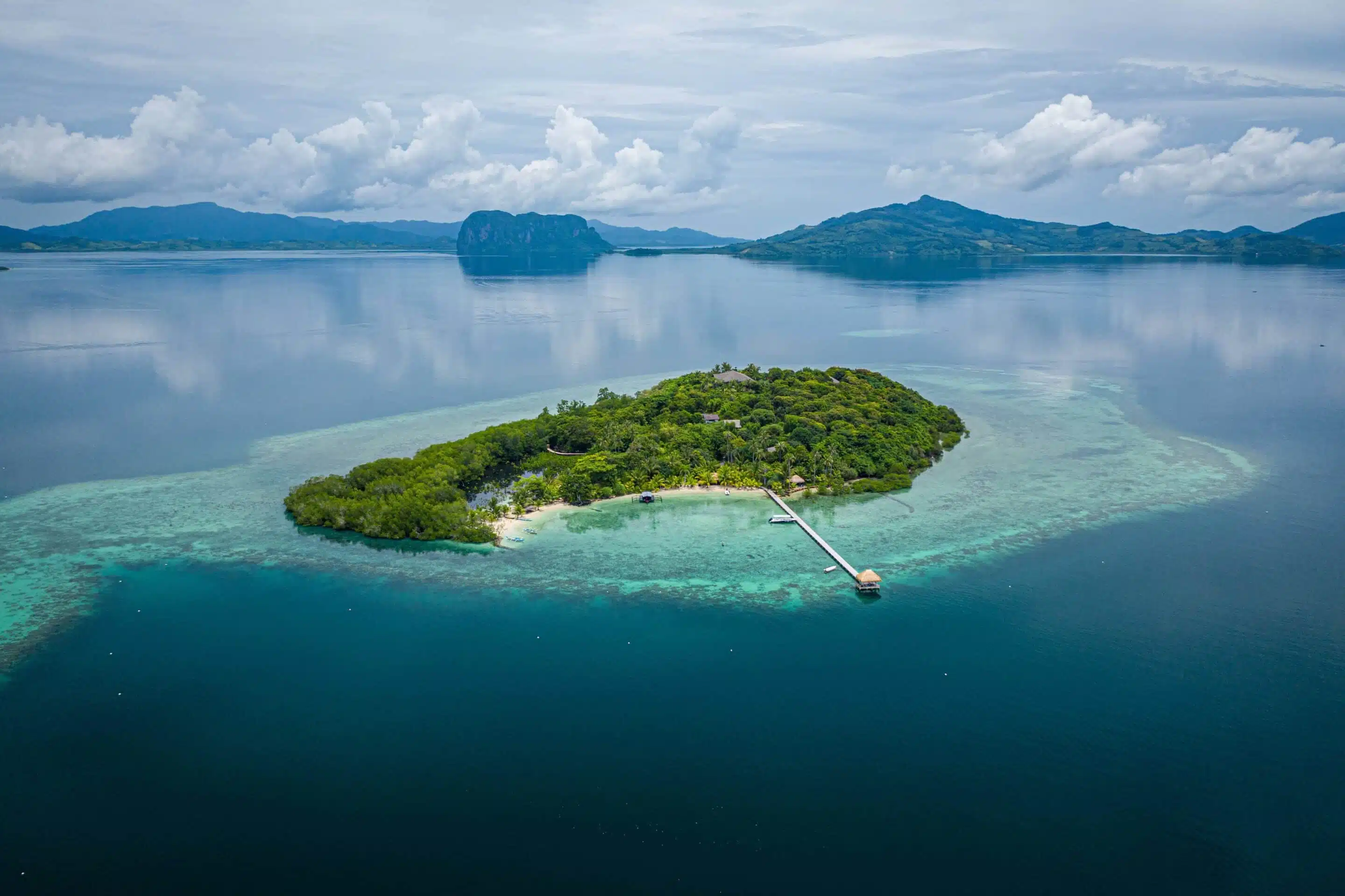 Vue aérienne sur une baie rocheuse donnant sur un lagon corallien en Nouvelle-Calédonie