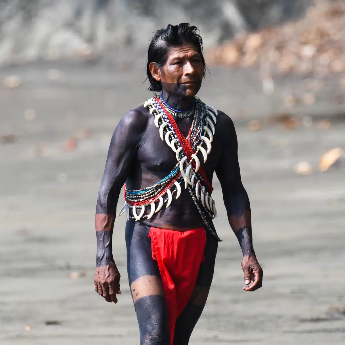 Homme Embera tatoué marchant sur la plage