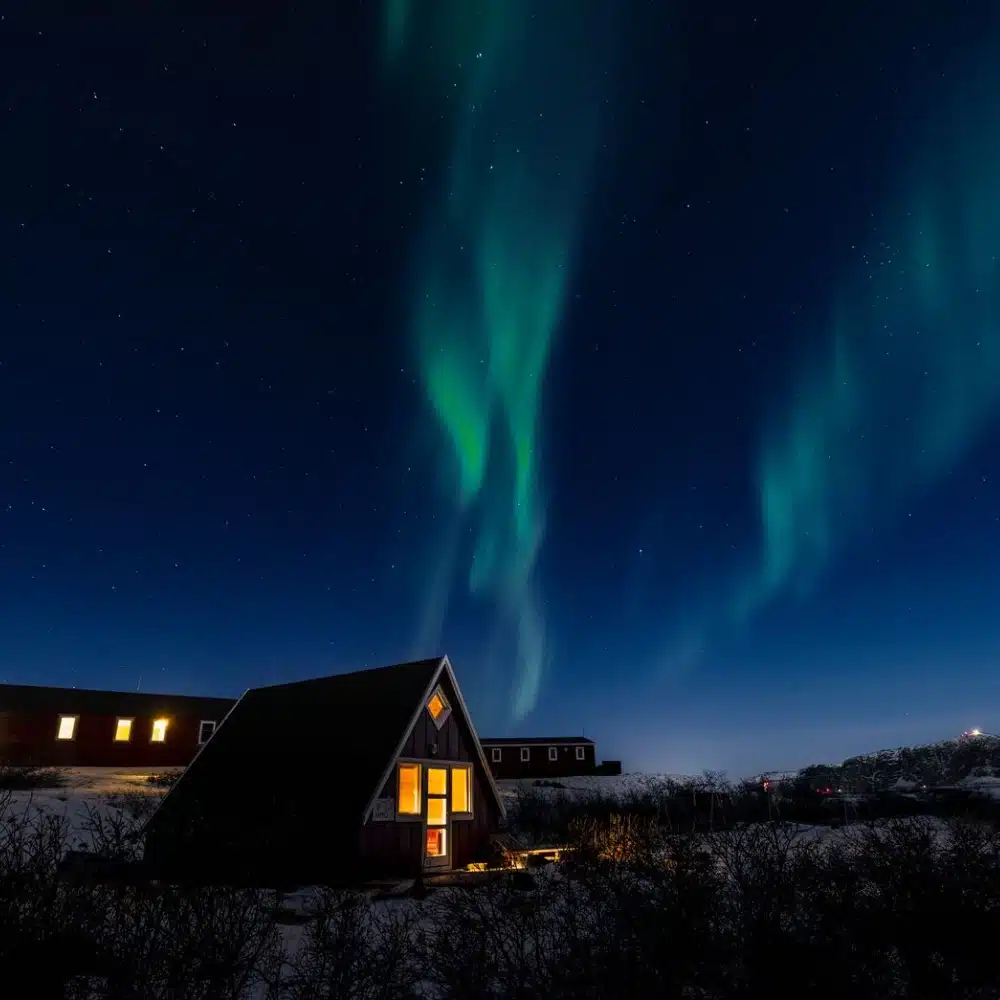 travelling-arctic The aurora borealis above homes in Kullorsuaq, Greenland