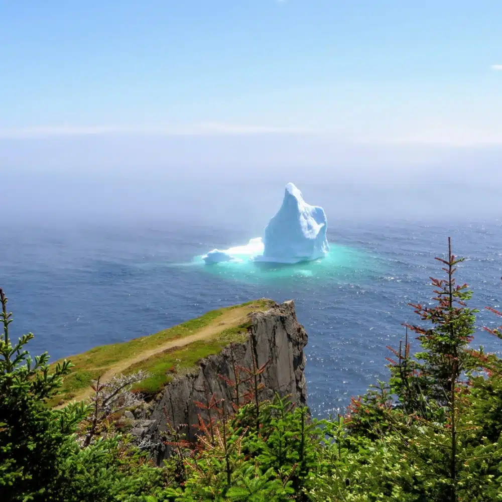quand-partir-canada Imposant iceberg dérivant au large des côtes verdoyantes de Terre-Neuve-et-Labrador